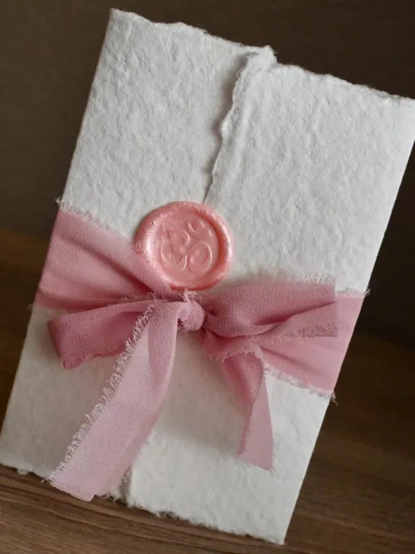 Geboortekaart van geschept papier met lint en lakzegel